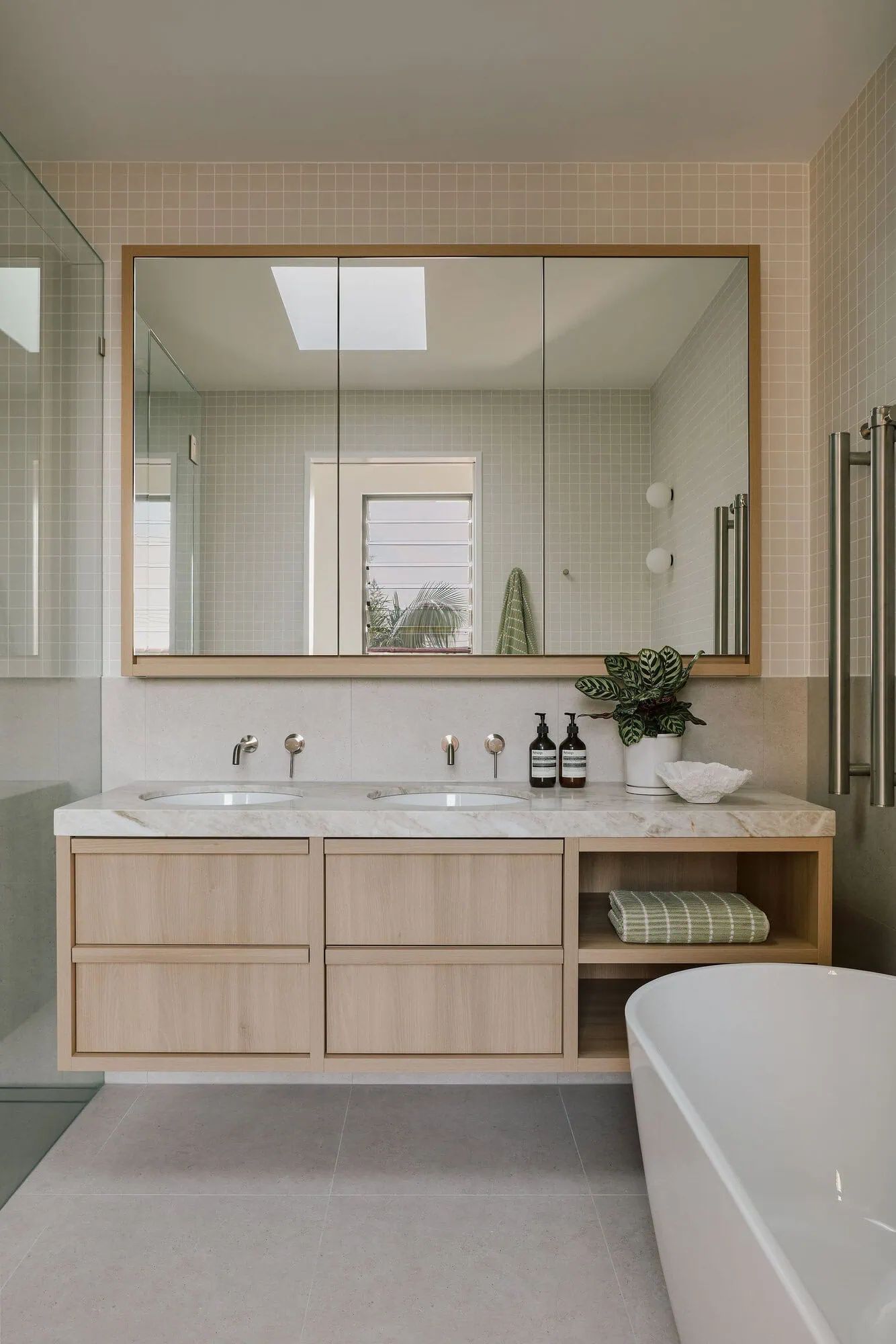 Timber vanity and marble bathroom with skylight