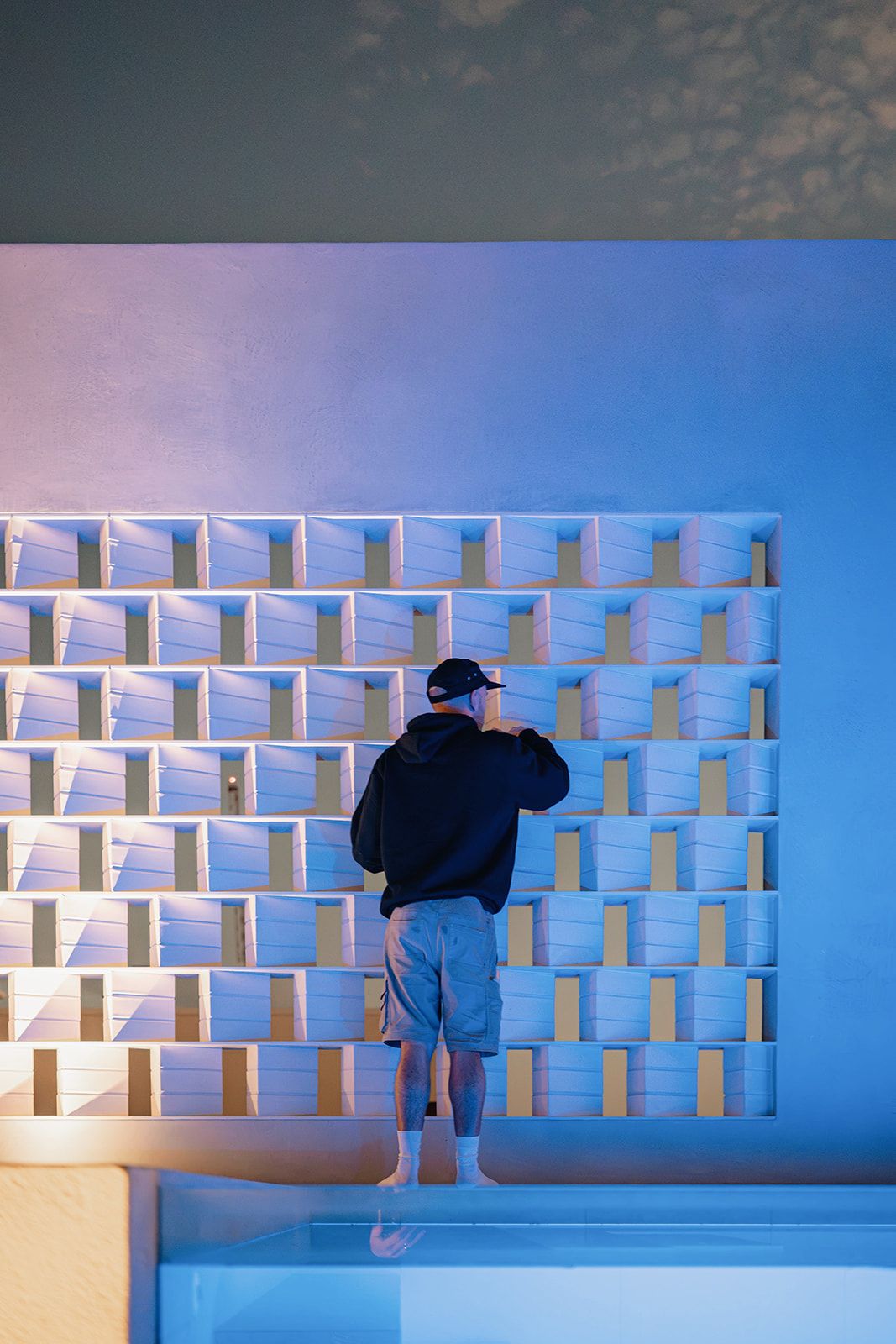 Sealing crew working on an illuminated breeze-block feature wall